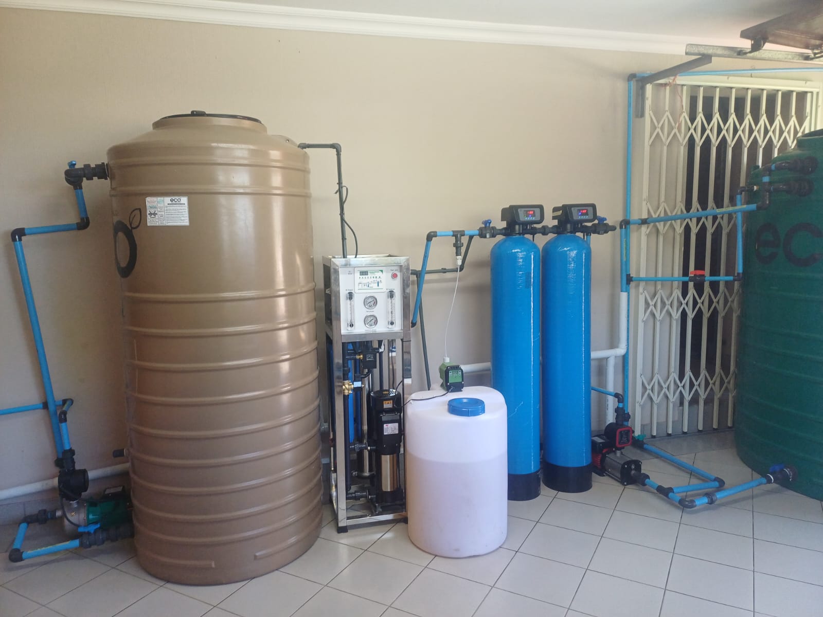 Water filtration and storage tank system installed with blue pipework