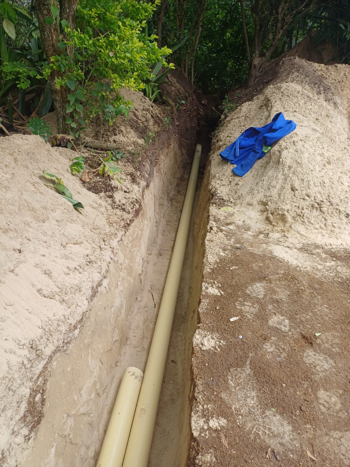 Neatly dug trench with new PVC sewer pipe laid to fall